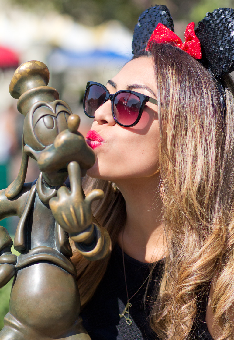 Alexis Alcala Giving a Kiss to a Statue of Goofy at the End of Main Street, U.S.A. at Disneyland