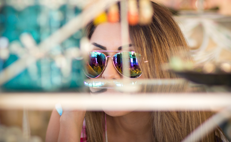 A Candid Photograph of Alexis Alcala Trying on Fashionable Sunglasses at a Small Boutique Store in Laguna Beach, California