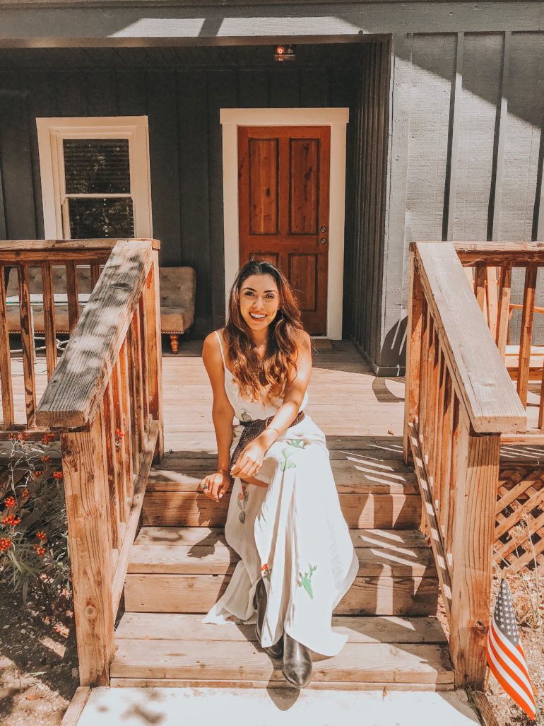 Alexis Alcala sitting on the porch of her air bnb in Los Alamos California